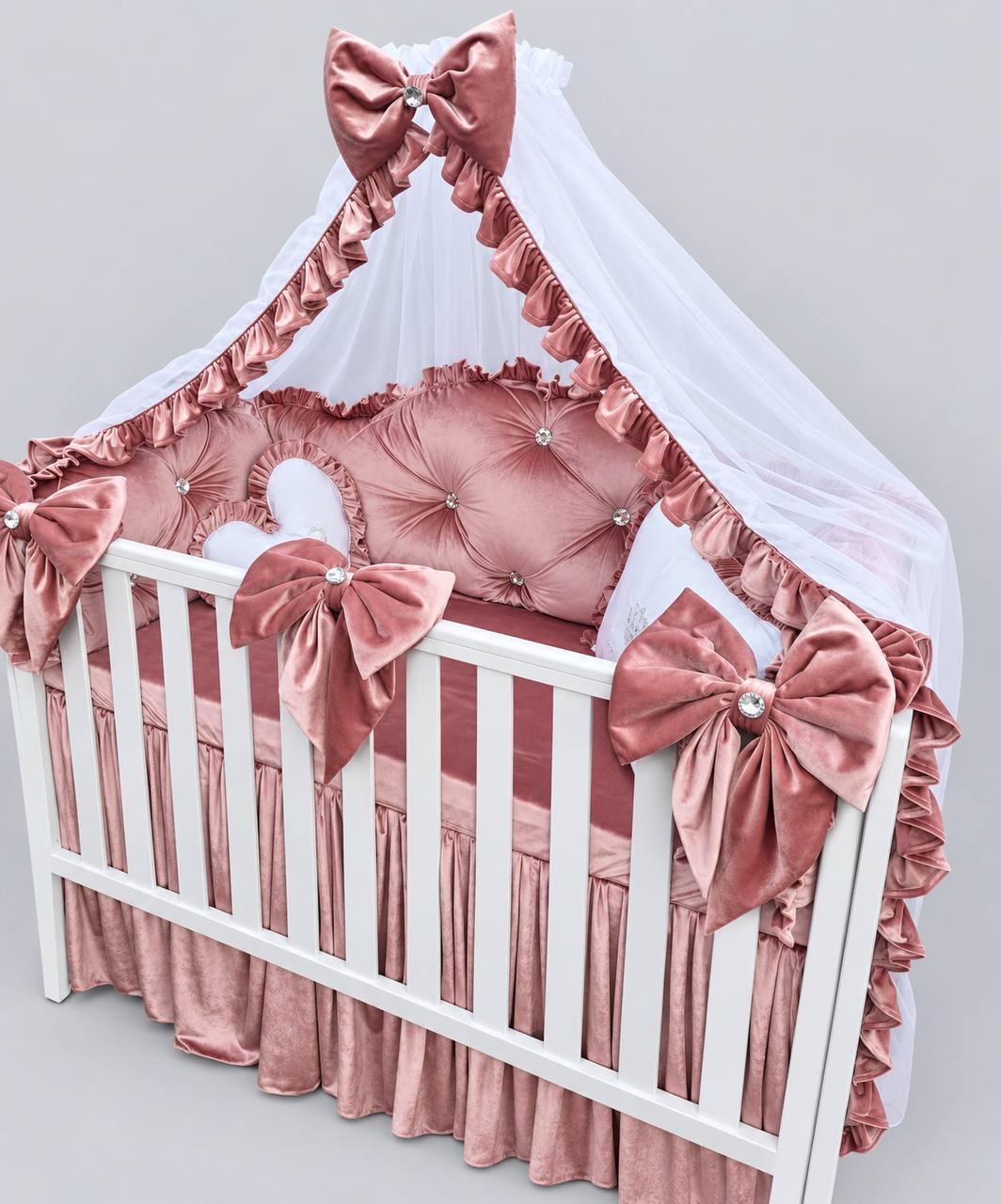 Dusty rose tufted crib bedding set with an oversized canopy bow